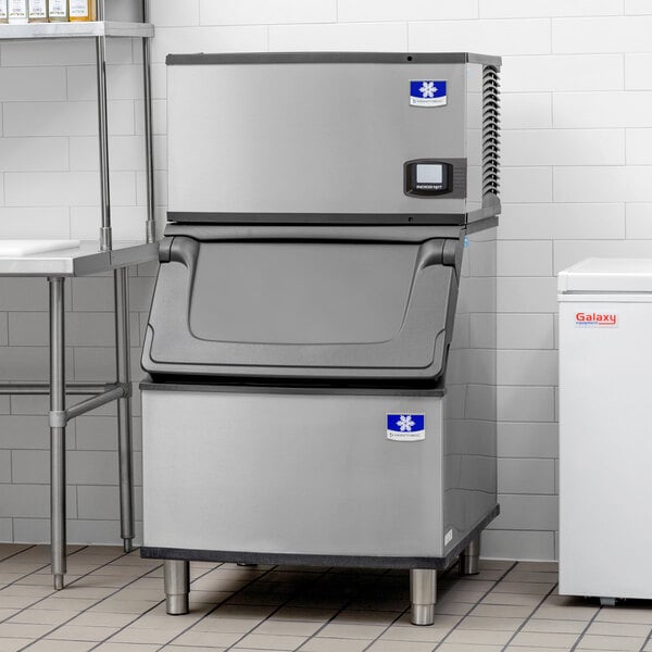A stainless steel air cooled Manitowoc ice machine with a black lid.