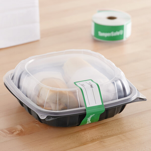 A plastic container with a roll of green TamperSafe paper labels.