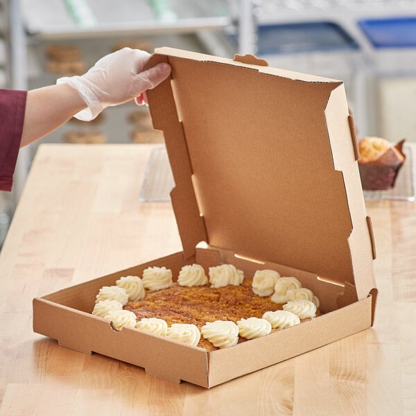 A person holding a Choice Kraft pizza box on a table with food inside.