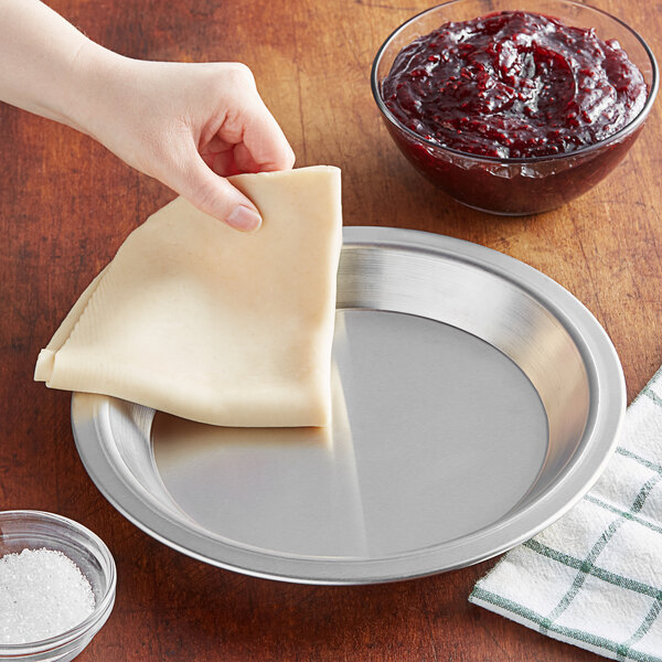 An American Metalcraft aluminum pie pan with a piece of pie on a plate.