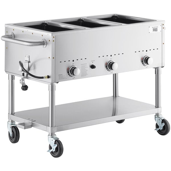 A large stainless steel Backyard Pro outdoor steam table with three pans and wheels.