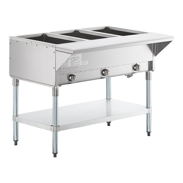 A stainless steel three-pan open well natural gas steam table with an undershelf and control knobs.