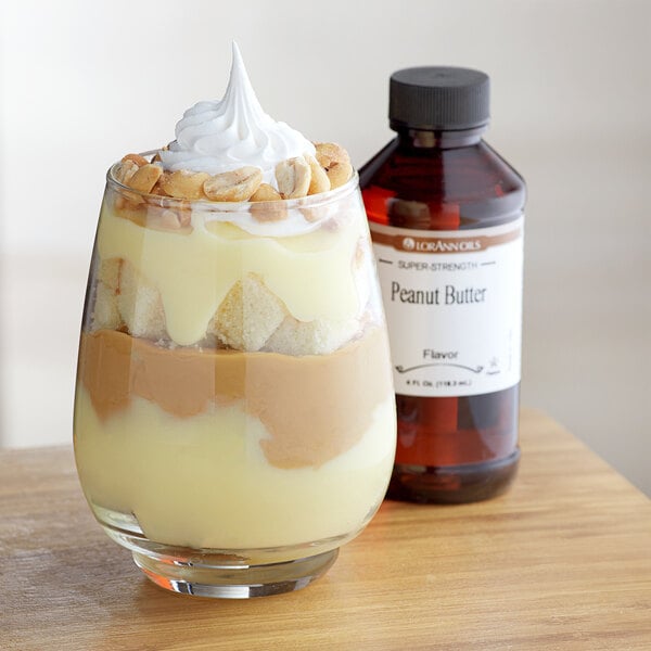 A glass of dessert with peanut butter and whipped cream.