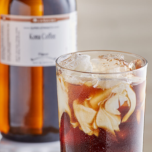 A glass of iced Kona coffee with a brown bottle of Kona coffee flavoring.