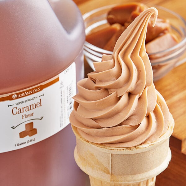 A scoop of caramel ice cream with a bottle of LorAnn Caramel Super Strength Flavor on a table.