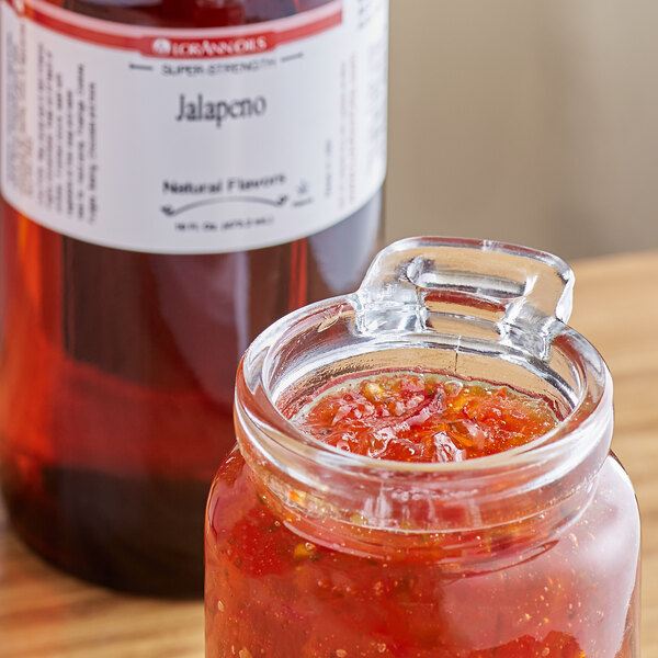 a jar of red sauce next to a bottle of liquid