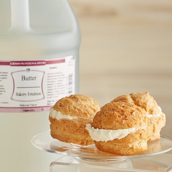 A clear plate of pastries with a jug of LorAnn All-Natural Butter Bakery Emulsion next to it.