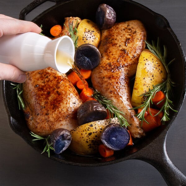 A person pouring Admiration Cooking Sherry into a pan of chicken.