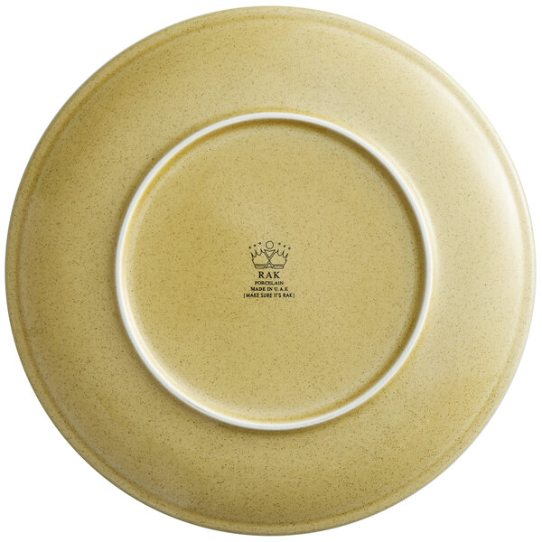 A close up of a RAK Porcelain Genesis Creme Brule flat porcelain coupe plate with a white rim.