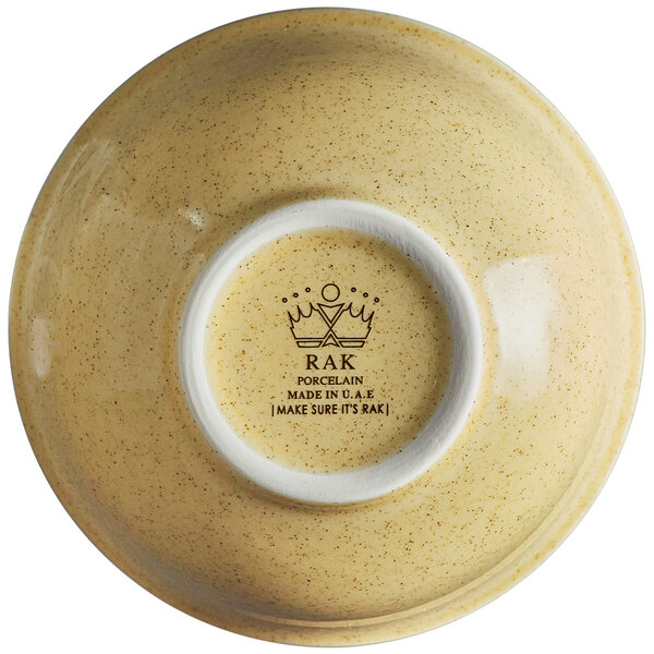 A close up of a RAK Porcelain Genesis glossy round creme brule bowl with a yellow crown on it.