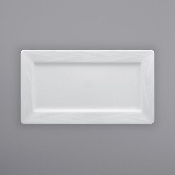 A RAK Porcelain bright white rectangular porcelain plate on a gray surface.