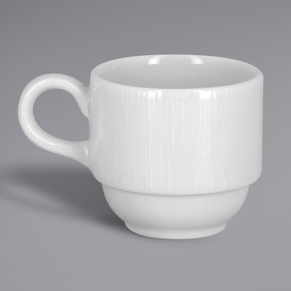A close-up of a RAK Porcelain white espresso cup with an embossed design and a handle.