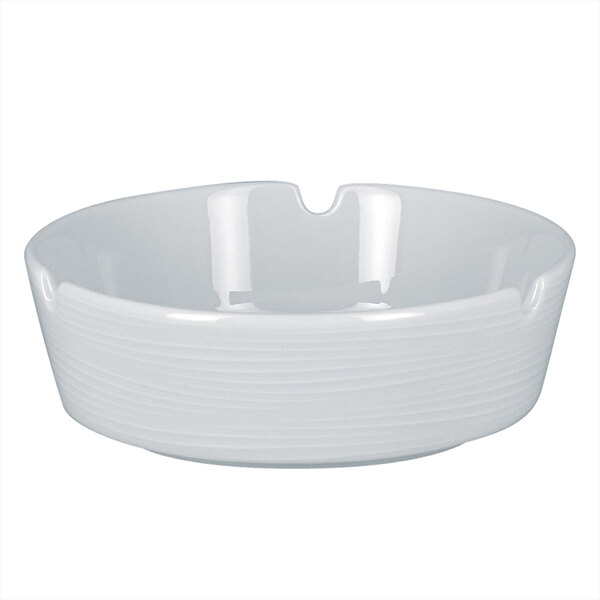 A white RAK Porcelain ashtray with an embossed design.