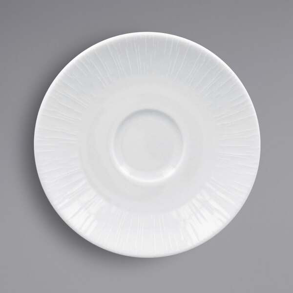 A close-up of a RAK Porcelain Soul bright white saucer with a circular pattern.