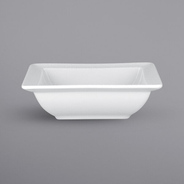 A bright white square porcelain bowl with an embossed pattern.