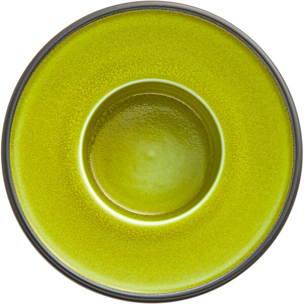 A green porcelain saucer with a black rim.