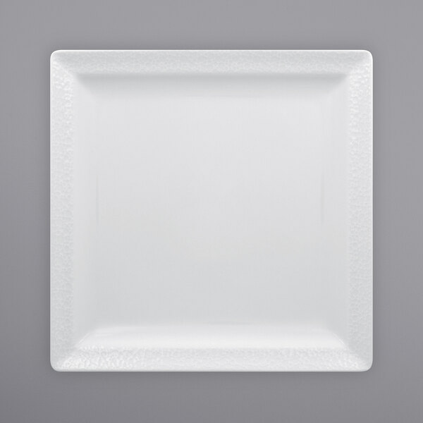 A white square RAK Porcelain plate with a textured surface.