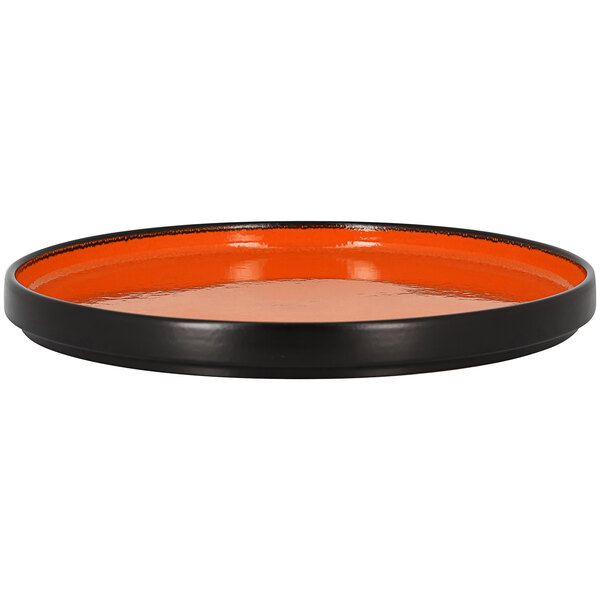 A black and orange rimless porcelain deep plate with an orange rim on a table.