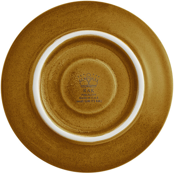 A close up of a RAK Porcelain caramel saucer with a white rim and gold accents.