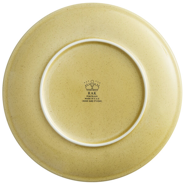 A close up of a yellow RAK Porcelain coupe plate with a white rim.