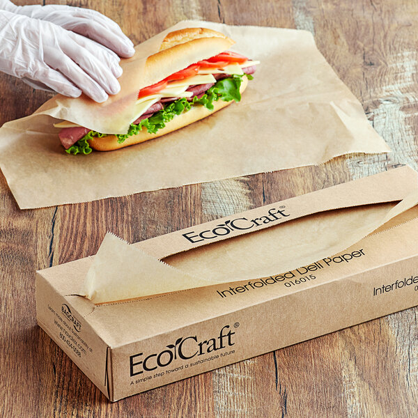 A person in white gloves wrapping a sandwich in Bagcraft EcoCraft deli paper.