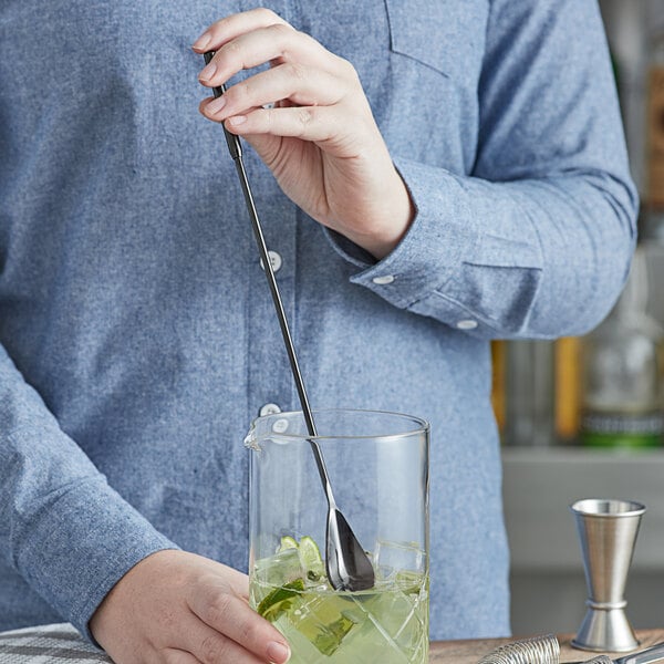 An American Metalcraft black stainless steel bar spoon stirring a drink.