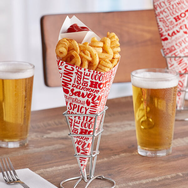 A Carnival King cardboard fry cone filled with French fries on a table with a glass of beer.