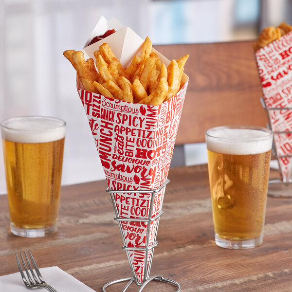 A Carnival King square cardboard fry cone filled with french fries on a table with two glasses of beer.