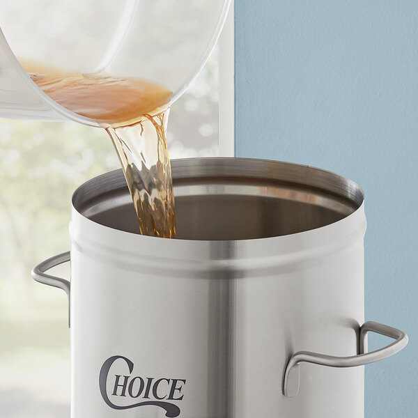 A liquid being poured into a stainless steel Choice 3 gallon iced tea dispenser.