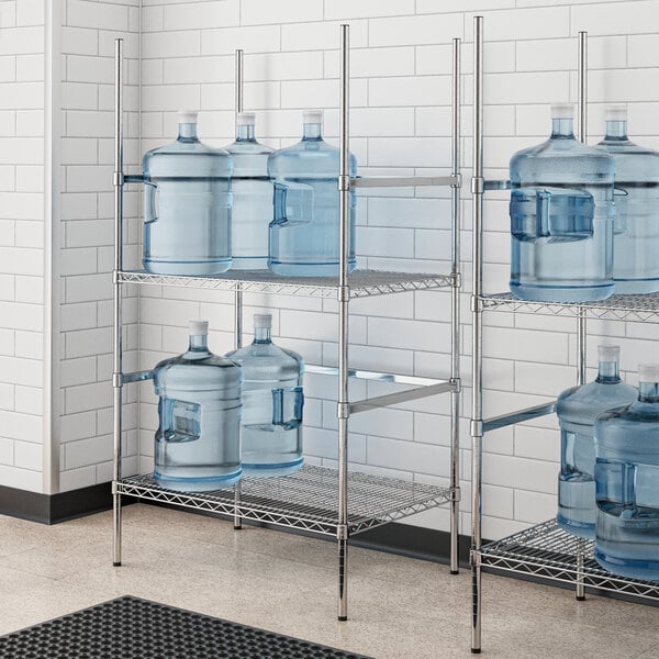 A chrome wire shelf rack holding water jugs.