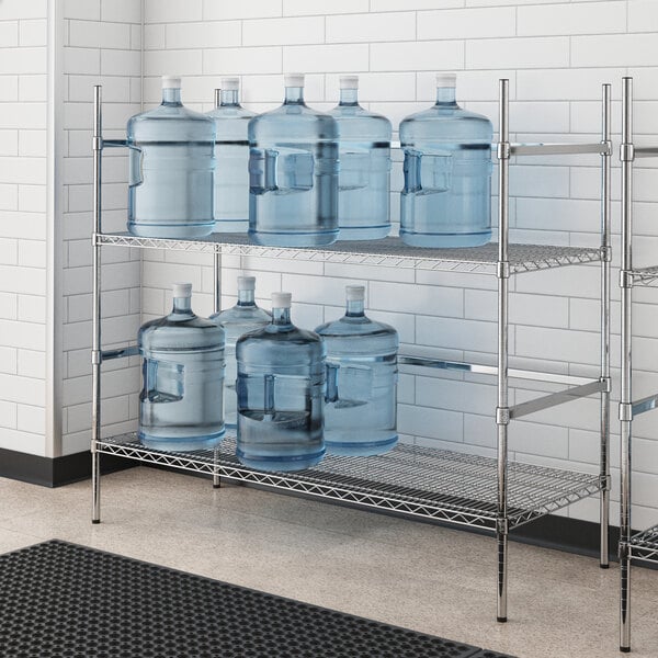 A Regency metal wire rack with two shelves holding water jugs.