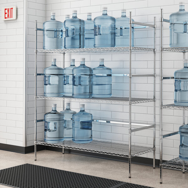 A metal wire shelf with three shelves holding water jugs.