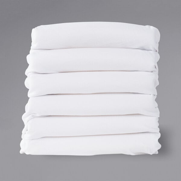 A stack of white rectangular Foundations SafeFit compact crib fitted sheets.