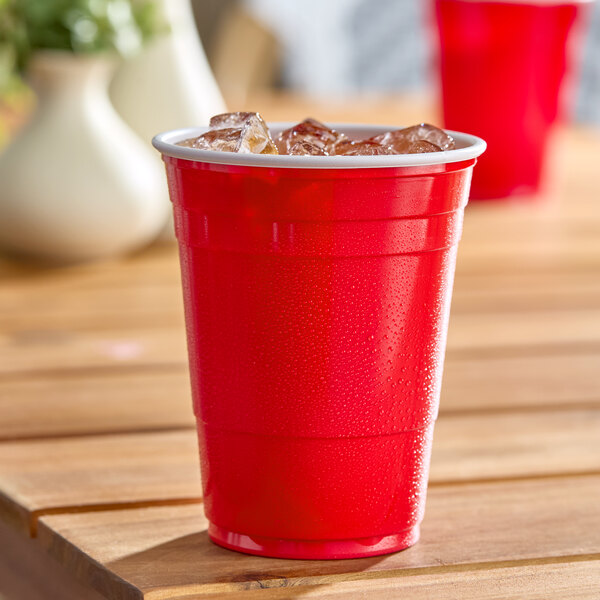 A red plastic cup filled with ice, commonly used for beverages at parties.