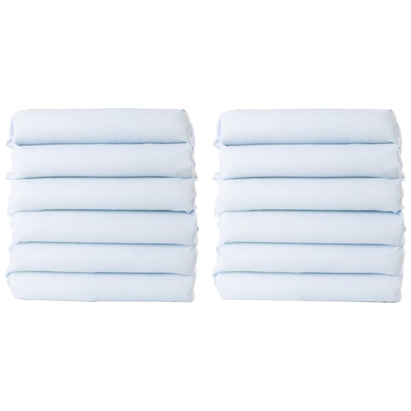 A stack of folded white Foundations CozyFit toddler cot sheets.