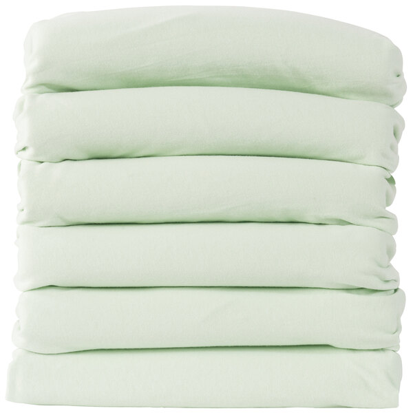 A stack of six white sheets with green borders on a white rectangular object.