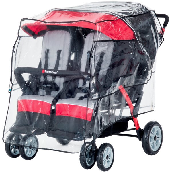 A transparent vinyl rain shield covering a Foundations stroller with two red and black seats.