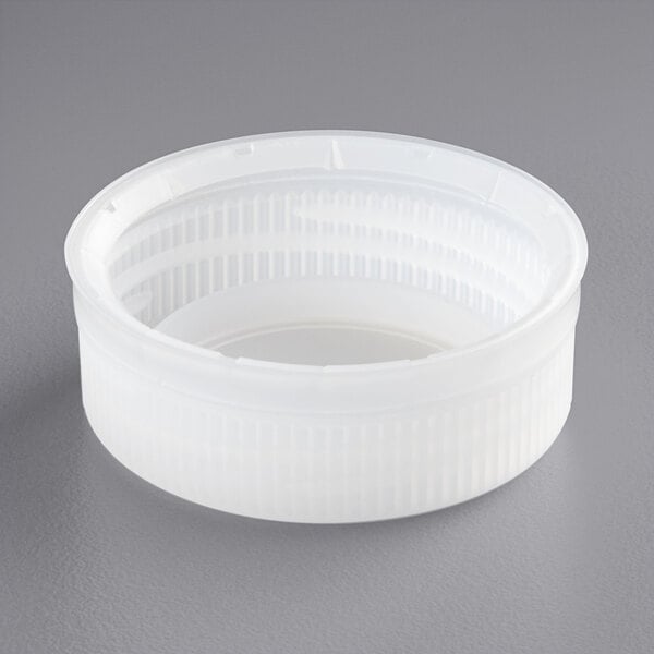 A close up of a clear tamper-evident cap with a circle in the middle.