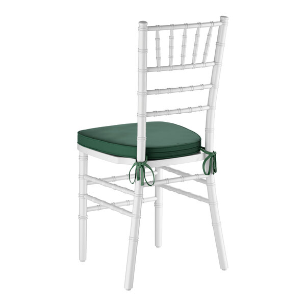 A white wood Chiavari chair with a green cushion tied to the seat.