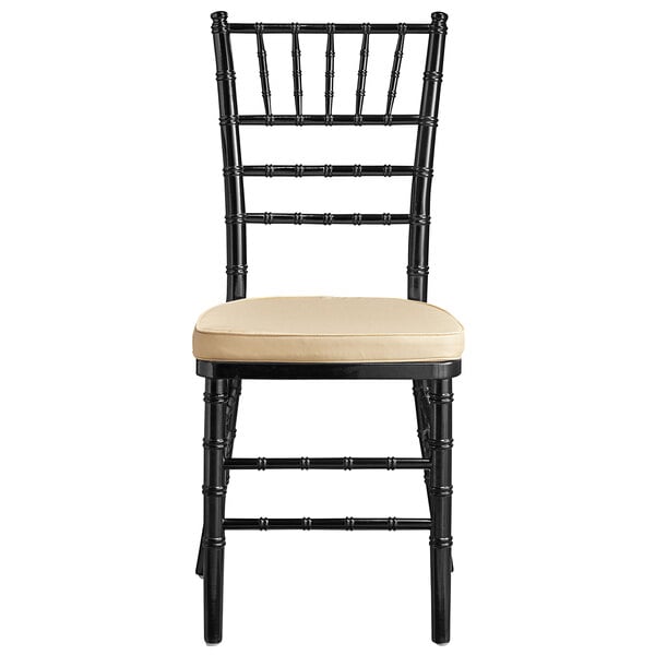 A black Lancaster Table & Seating Chiavari chair with a tan cushion.