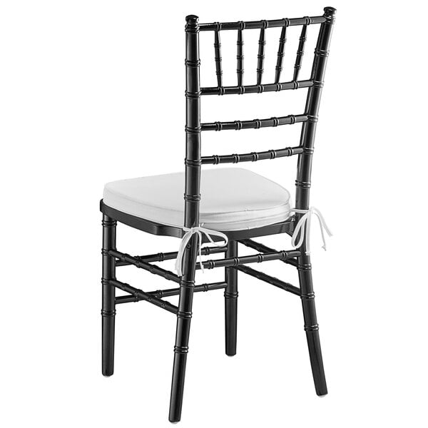 A black Lancaster Table & Seating Chiavari chair with a white cushion.
