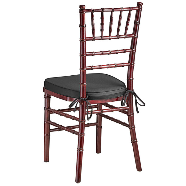 A Lancaster Table & Seating mahogany Chiavari chair with a black cushion.