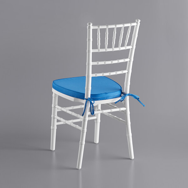 A white Lancaster Table & Seating Chiavari chair with a blue cushion.