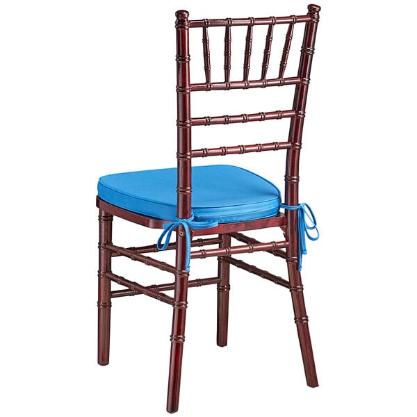 A Lancaster Table & Seating mahogany Chiavari chair with a blue cushion.