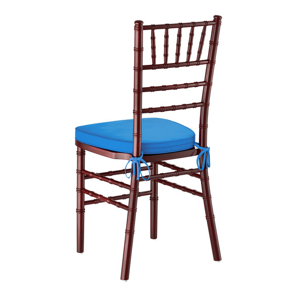 A mahogany wood Chiavari chair with a blue cushion tied to the seat.