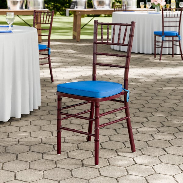 A mahogany wood Chiavari chair with a blue cushion.
