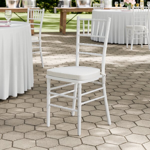 A white wood Chiavari chair with an ivory cushion.