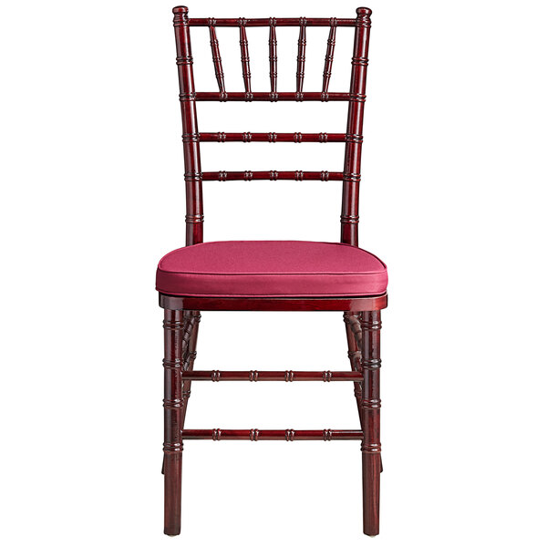 A Lancaster Table & Seating mahogany Chiavari chair with a wine red cushion.