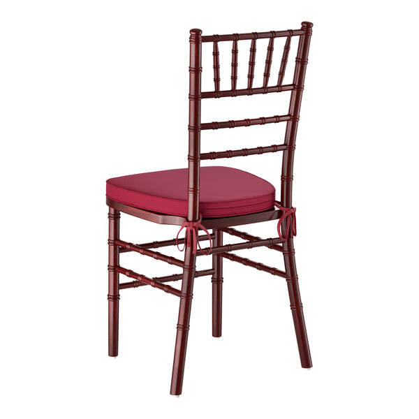 A mahogany wood Chiavari chair with a wine red cushion.