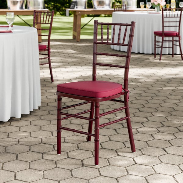 A mahogany wood Chiavari chair with a wine red cushion.